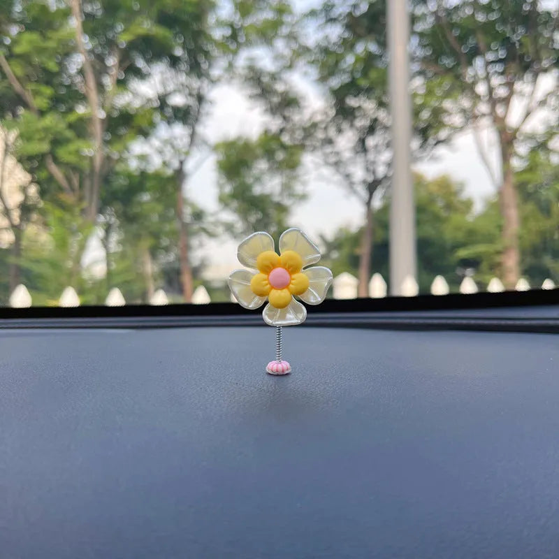 Small blue plastic swing decoration for a car dashboard, shown next to a coin for scale.