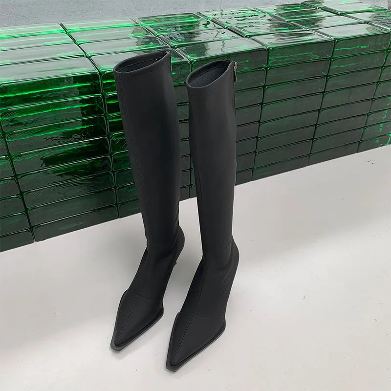 Women's black pointed toe stiletto heel boots with a back zipper, showing the below-the-knee shaft.