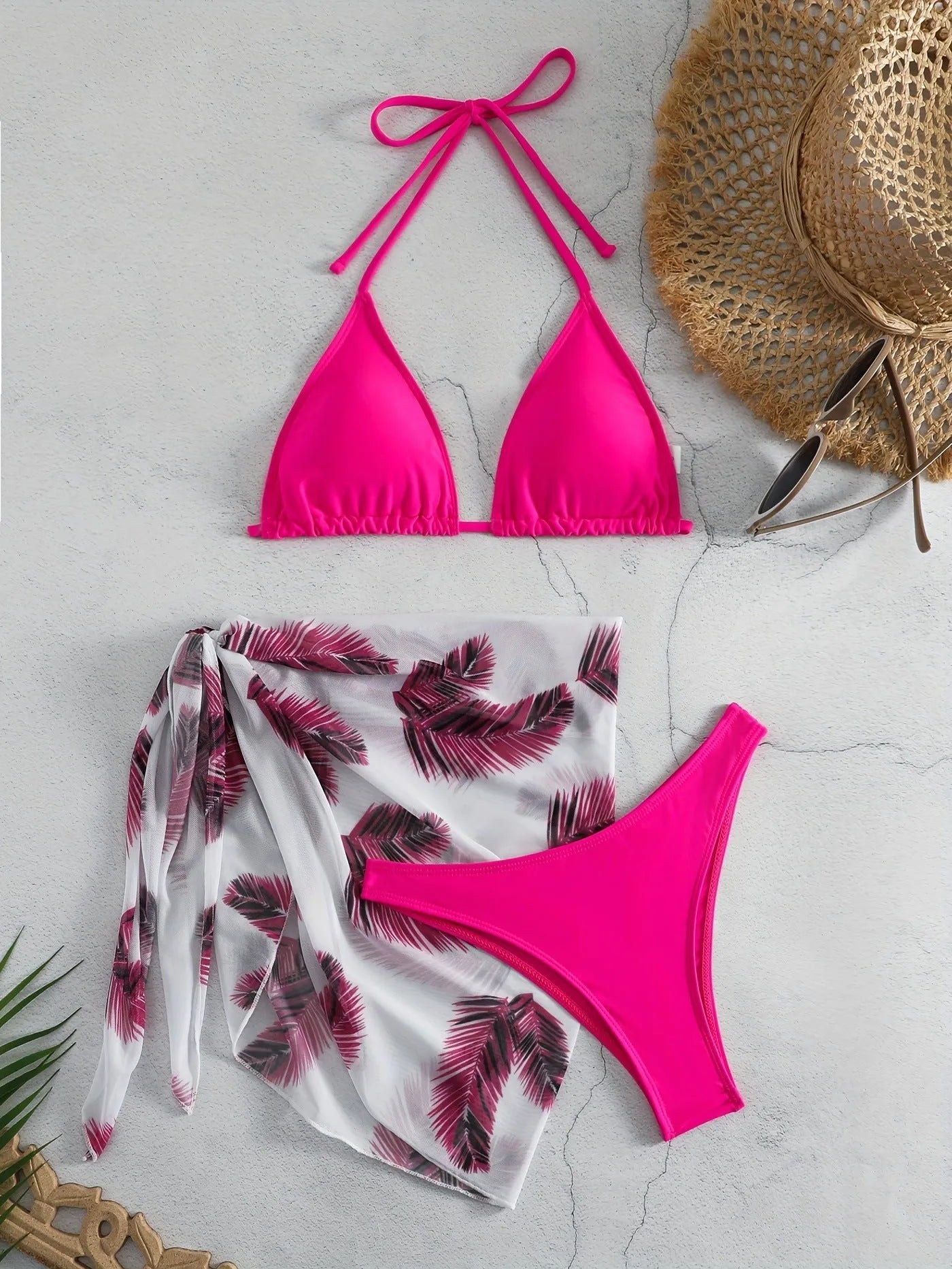 Orange three-piece bikini swimsuit set with a matching printed gauze skirt laid flat.