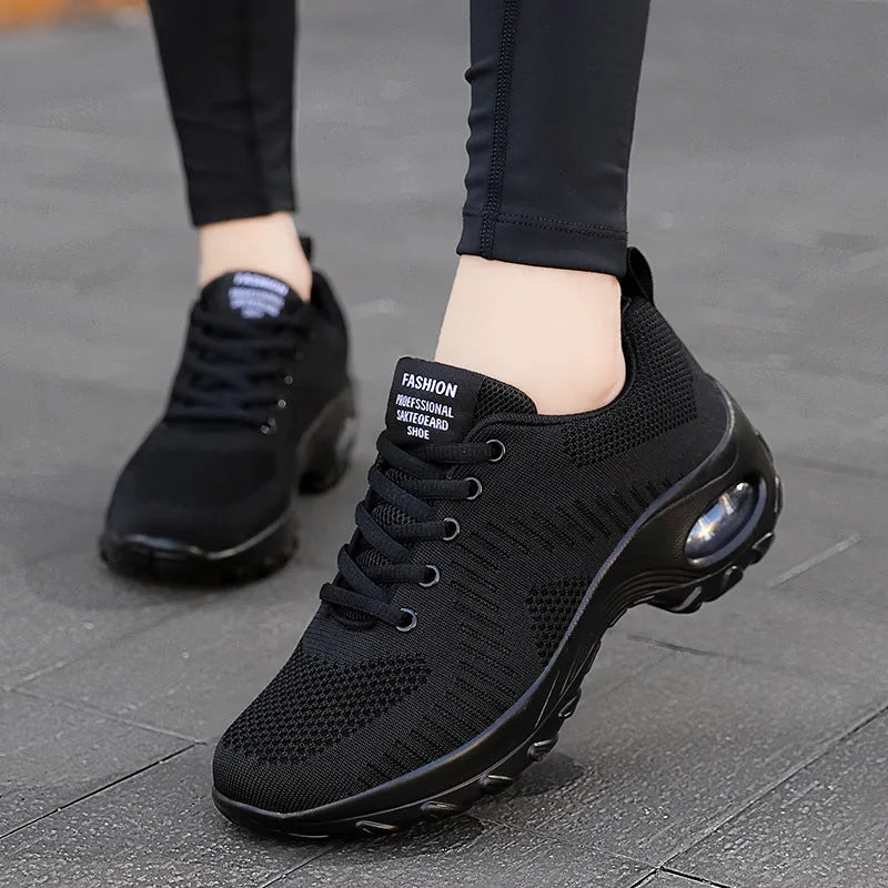 Black and red women's low-top mesh sneakers with round toe and lace-up front.