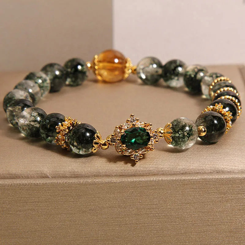 Women's gold rutilated quartz crystal bracelet with green phantom quartz accents, pearls, and rhinestones.