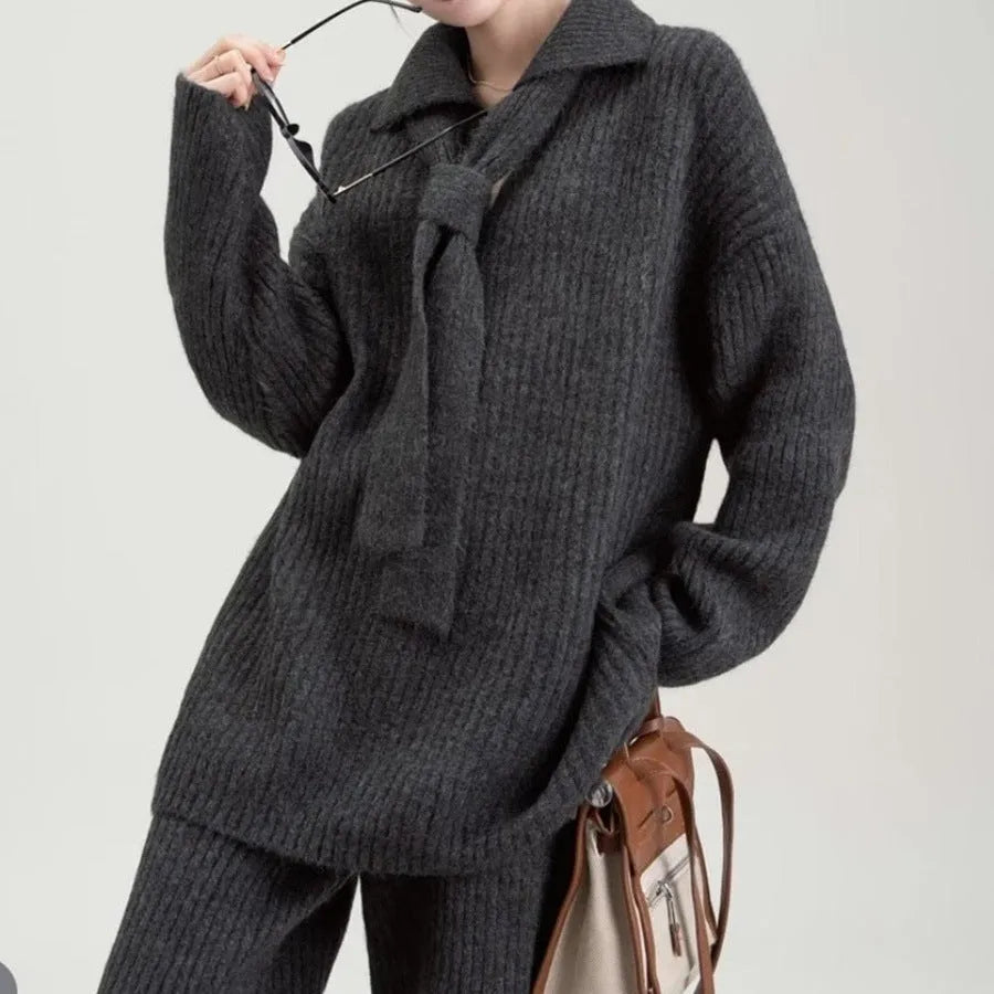 Women's dark grey acrylic knit sweater suit two-piece set with long sleeves and casual trousers.