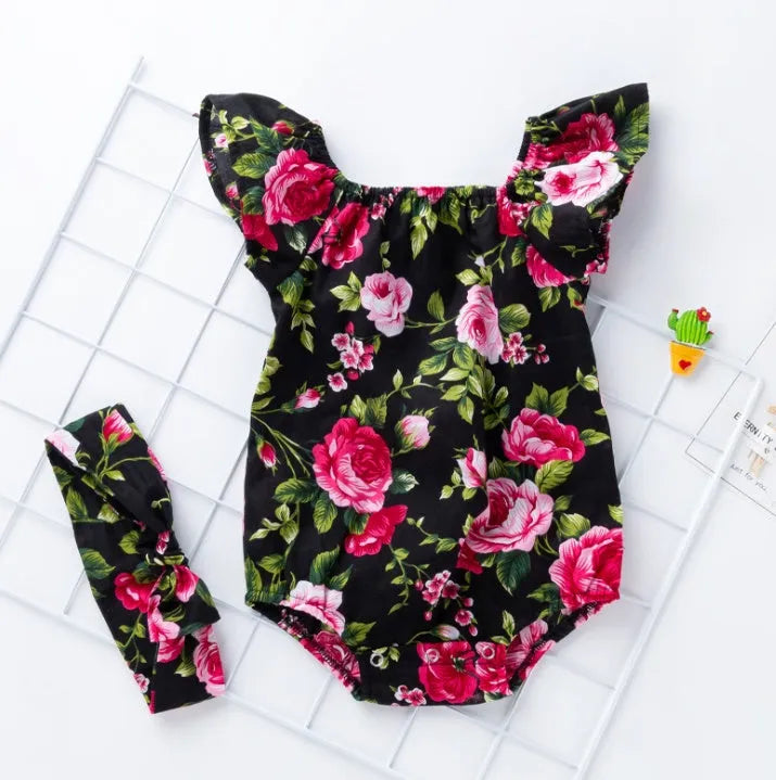 Baby girl wearing sleeveless black romper with small flying sleeves, triangle climbing style