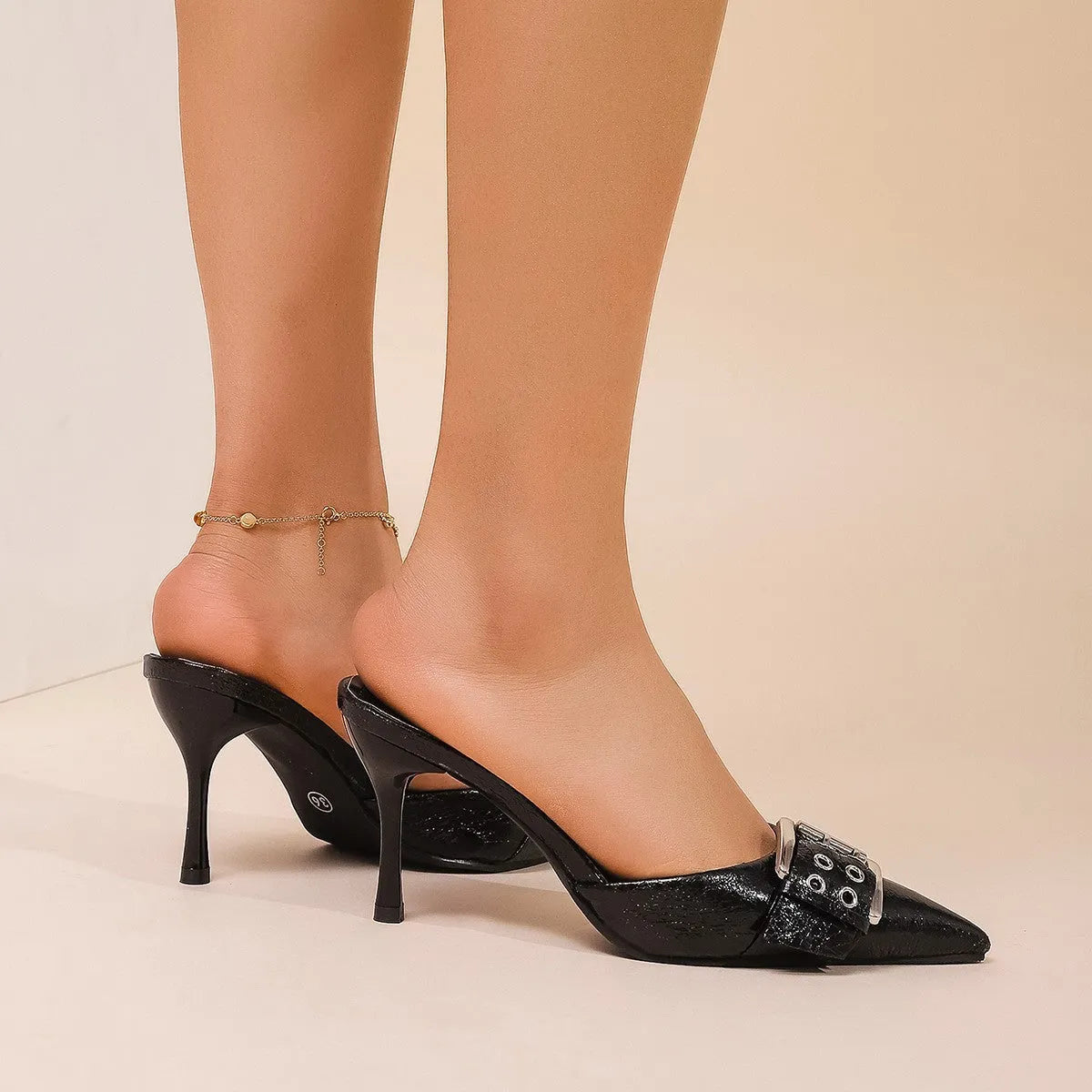 Black women's high heels with pointed toe and buckle strap detail in PU material