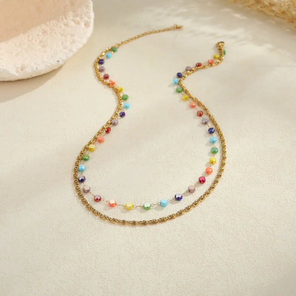 Gold-plated stainless steel double-layer necklace with colourful geometric beads on a white background
