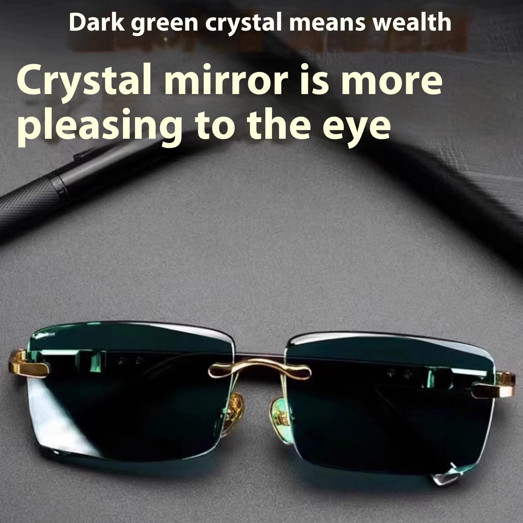 A pair of dark green frameless crystal sunglasses with a hard case and a lens cloth on a plain background.