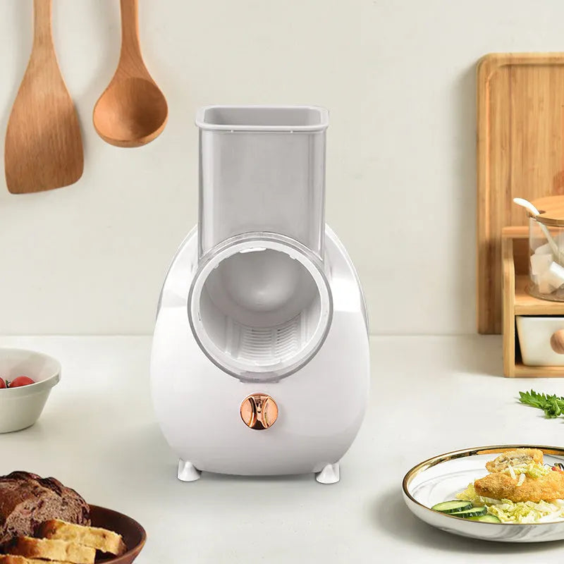 White electric vegetable slicer with suction base and multiple blades for grating and chopping.