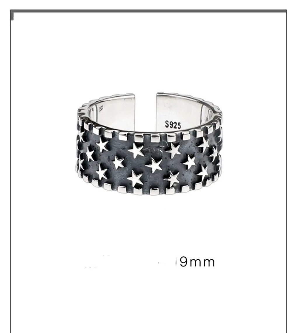 Adjustable open-ended sterling silver ring with a geometric multi five-pointed star pattern.