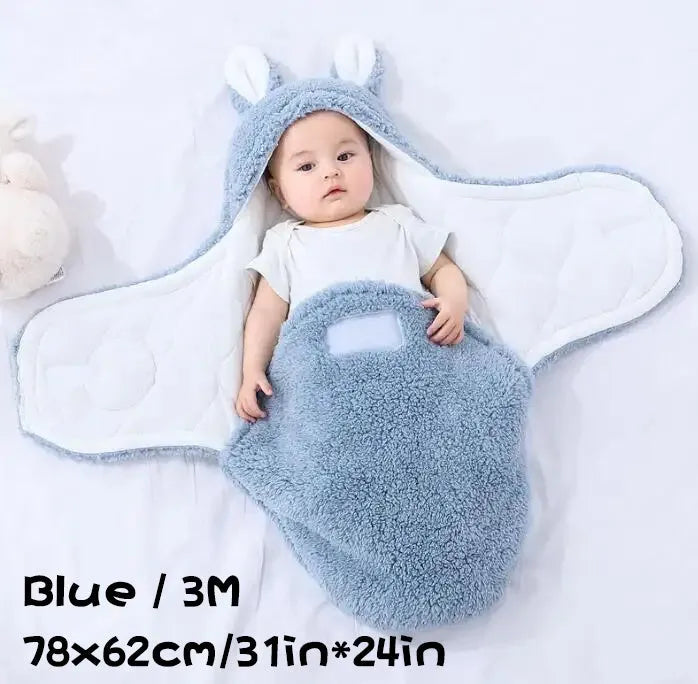 A baby wearing a soft grey fleece sleeping bag with hook-and-loop shoulder straps.
