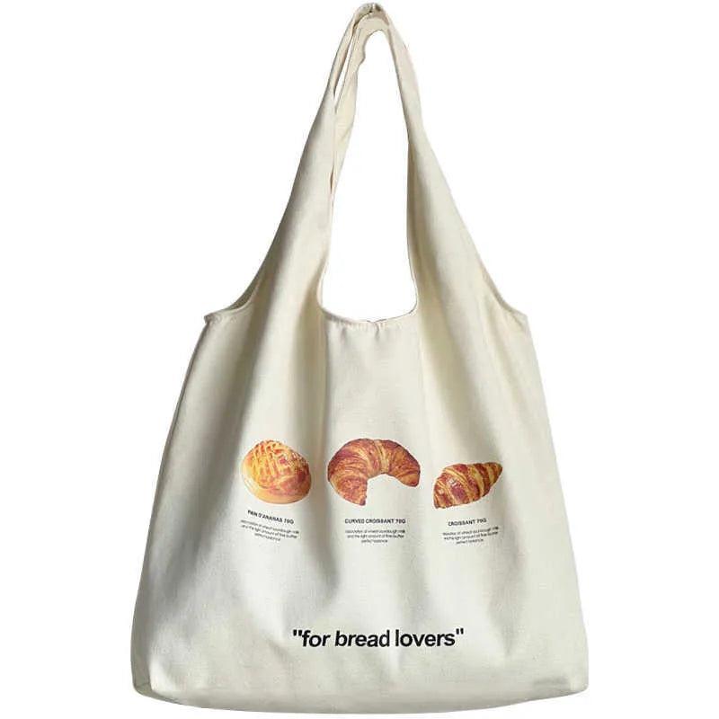Beige canvas one-shoulder tote bag with printed bread and croissant designs