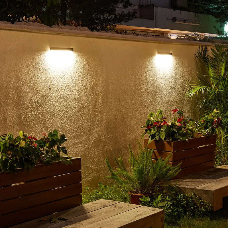 Black solar-powered outdoor wall lamp with solar strip, suitable for garden or yard.