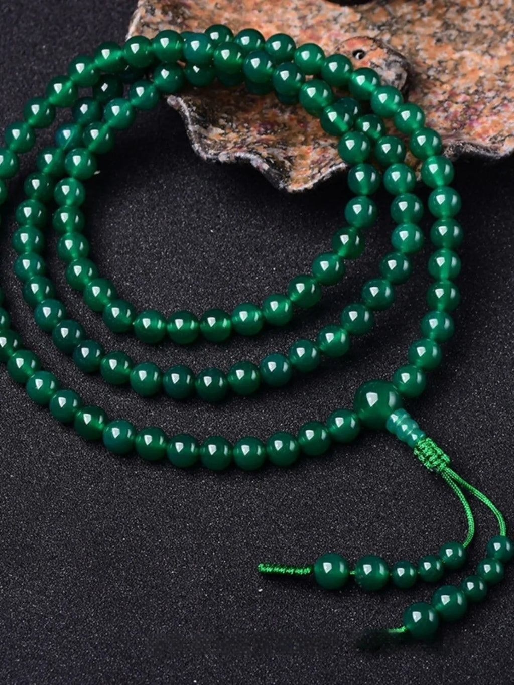 Handmade natural green agate 108 bead bracelet with thangka pendant on a wrist.