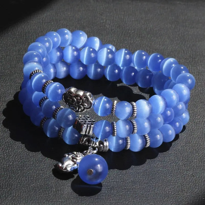 Women's adjustable opal bracelet with Lucky Cat charm and geometric beads in blue.
