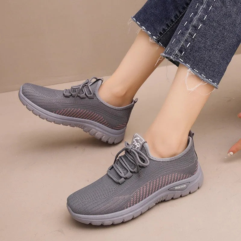 Women's black mesh sneakers with round toe, cross-strap details, and lace-up front on rubber sole