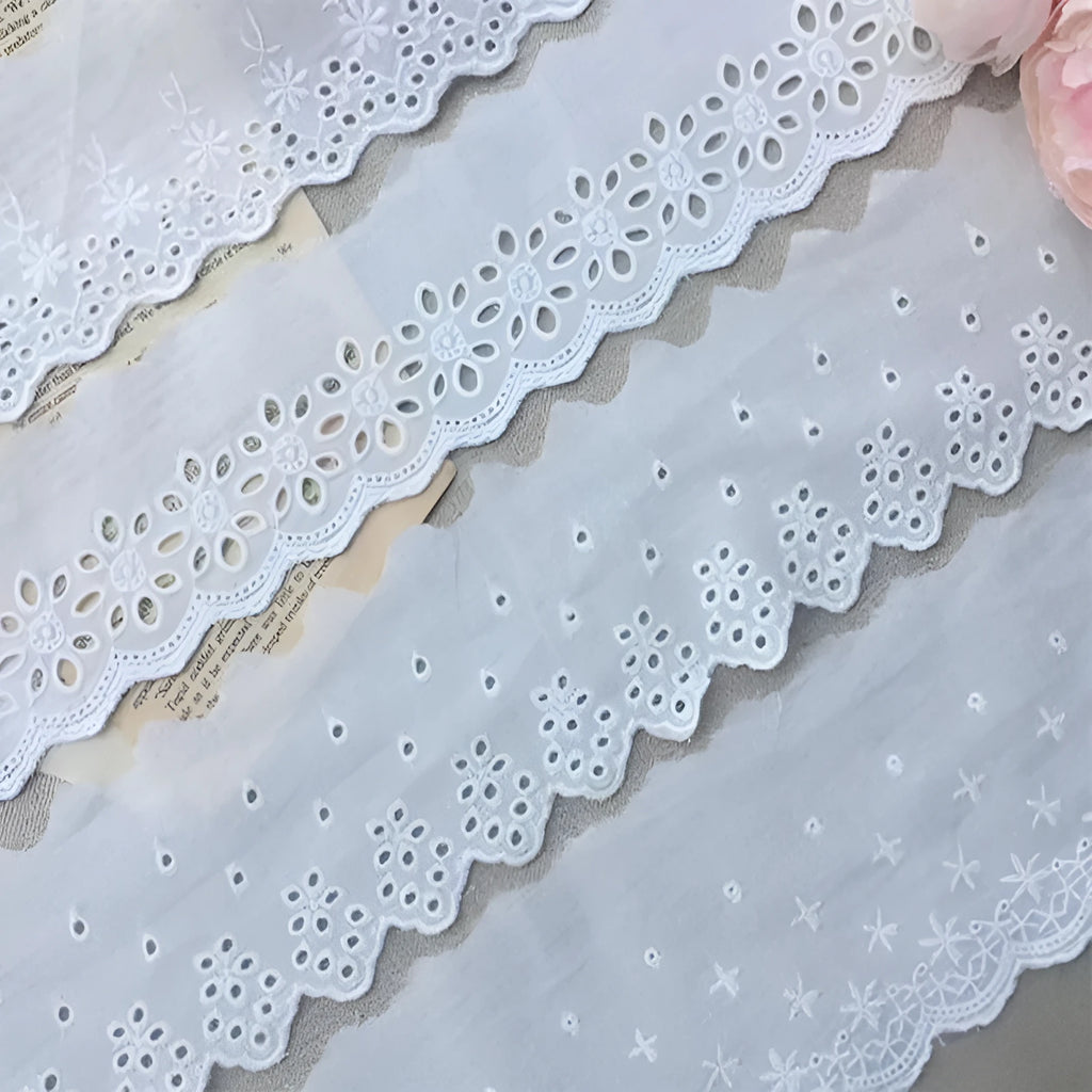 Cotton embroidered lace trim on roll showing cutout pattern, with width measurement examples