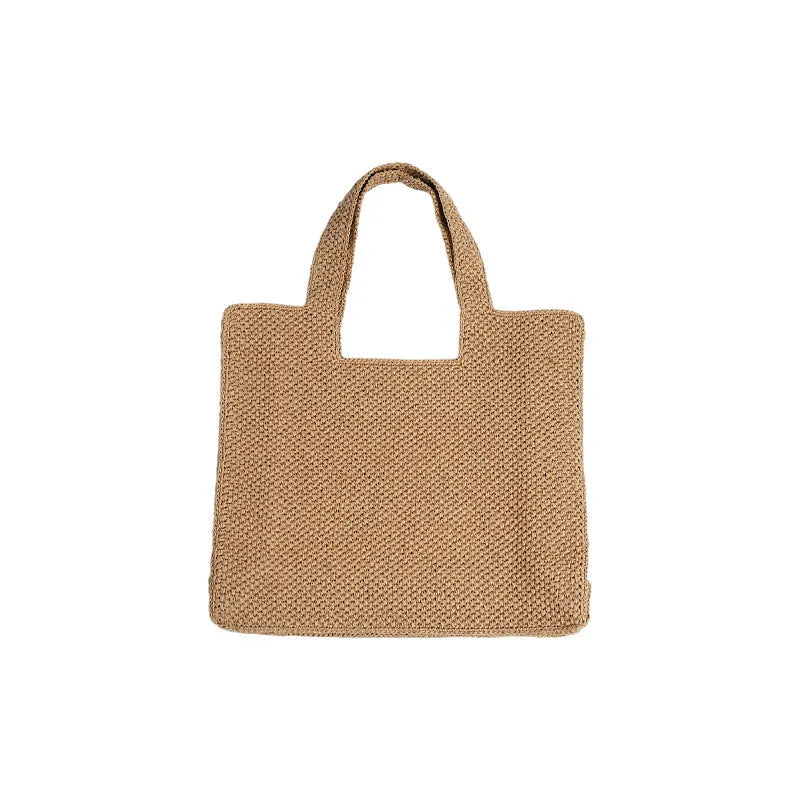 Khaki coloured woven straw tote bag with double straps showing open top and horizontal square shape.