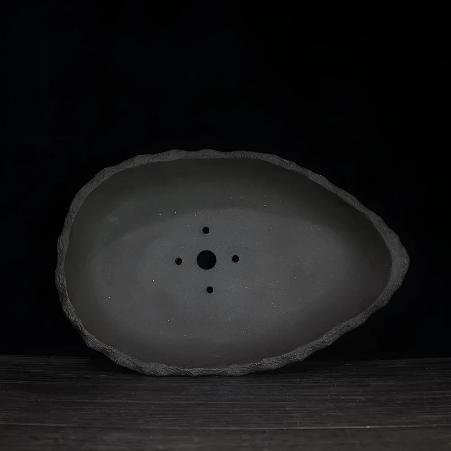 Handmade purple clay flower pot in a unique shape, shown as a floor-standing planter for indoor plants.
