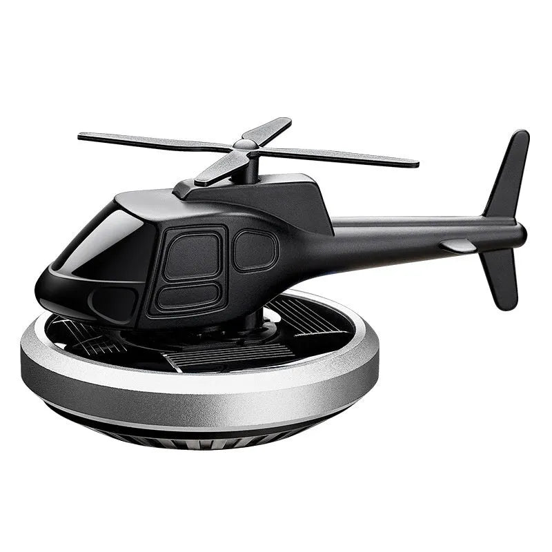 Silver metal solar helicopter car perfume ornament spinning on a car dashboard
