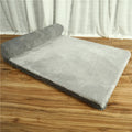 A corduroy dog sofa bed with raised sides in a grey colour, shown on a wooden floor.
