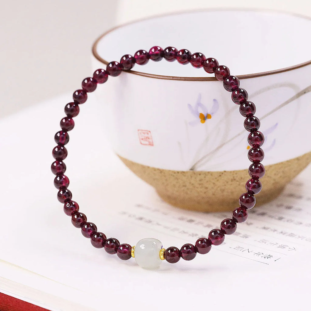 Women's garnet bracelet with U-shaped design showing polished stones in garnet colour