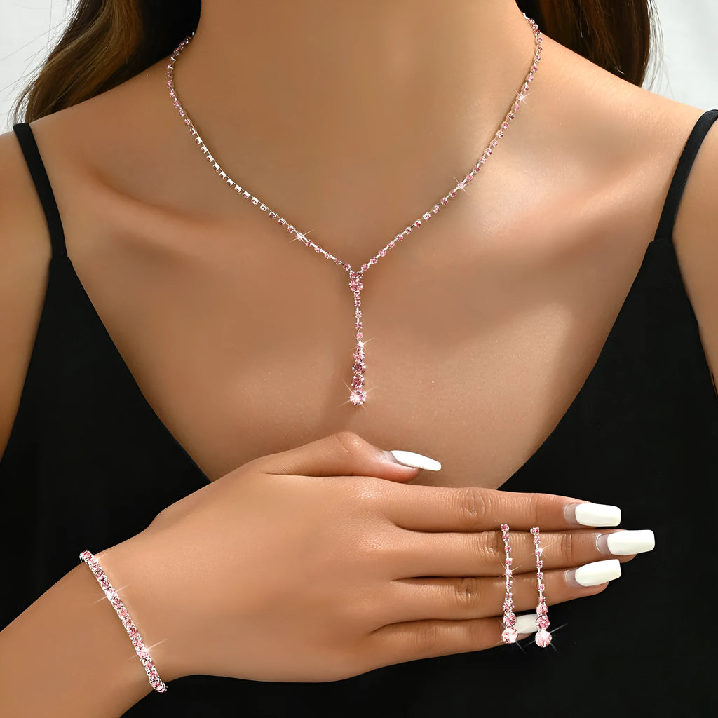 Three-piece bridal jewellery set showing necklace, bracelet and earrings with rhinestone pendant and heart-shaped design