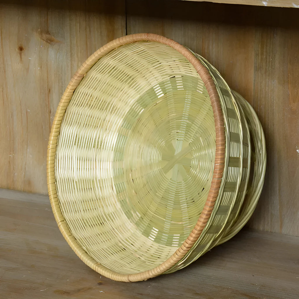 Handmade natural bamboo woven storage basket on a wooden surface.