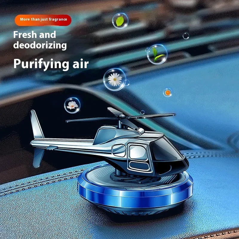 Silver metal solar helicopter car perfume ornament spinning on a car dashboard