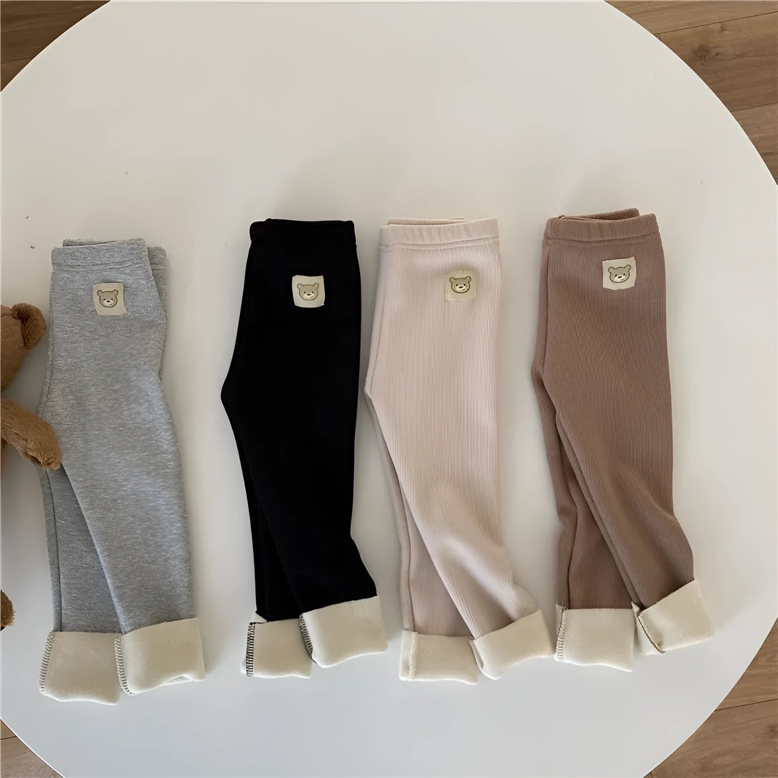 Girls' high-waist fleece-lined leggings in beige, shown with elastic hairband belt detail.