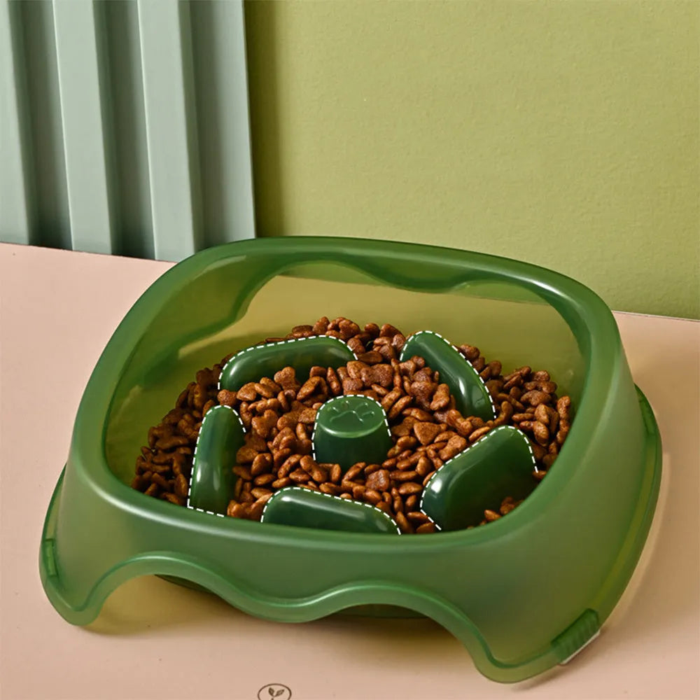 A blue plastic slow-feeder dog bowl on a wooden floor.