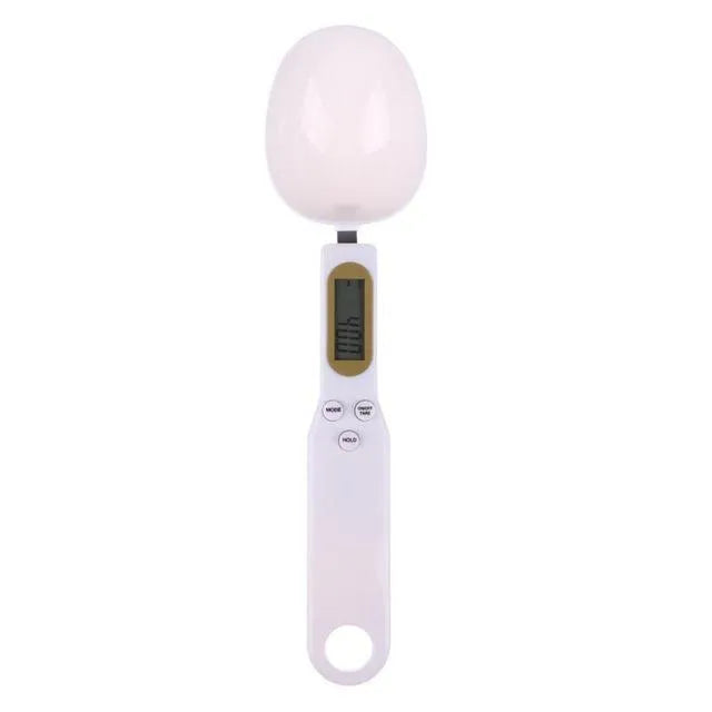 White digital spoon scale with LCD display showing weight measurement for kitchen ingredients