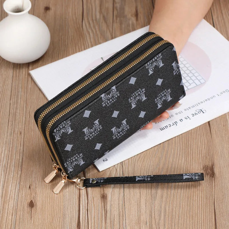 Black retro print long wallet clutch bag with zipper, holding a mobile phone and cards.