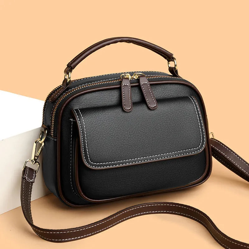 Women's black PU leather cross-body shoulder bag showing horizontal square shape and double straps