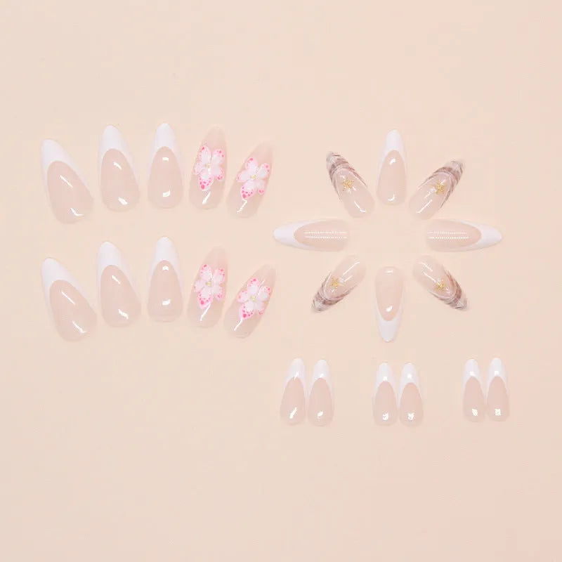 French style false nails with white tips and a black rock pattern patch featuring simple pink and white flowers.