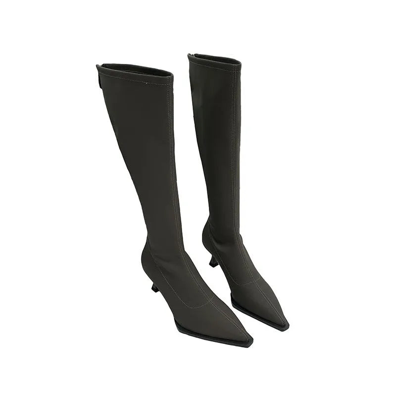 Women's black pointed toe stiletto heel boots with a back zipper, showing the below-the-knee shaft.
