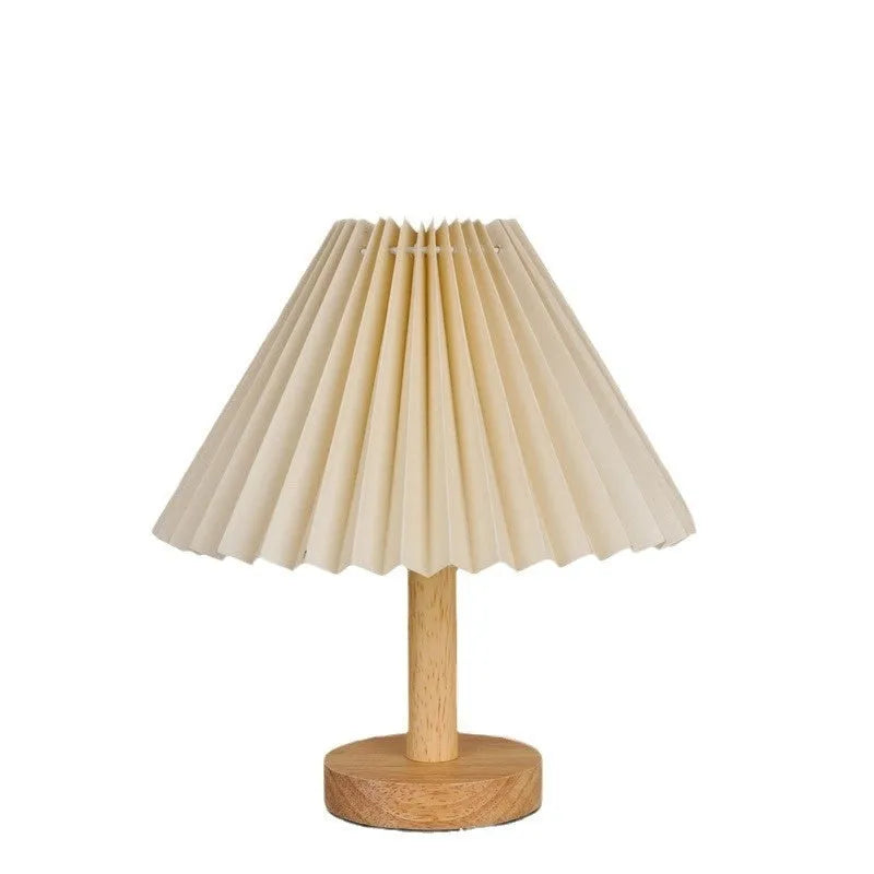 Vintage red pleated umbrella-shaped bedside lamp with remote control on a wooden nightstand.