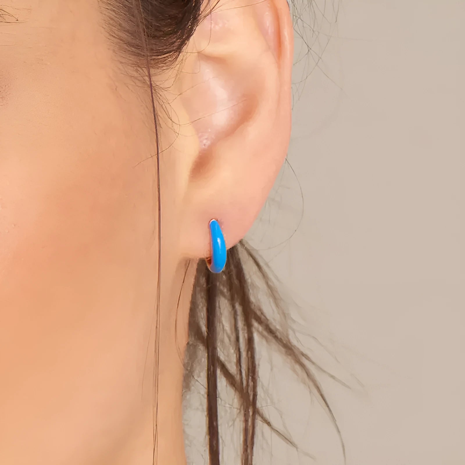 A pair of curved oval epoxy earrings on a U-shaped silver-plated copper base.