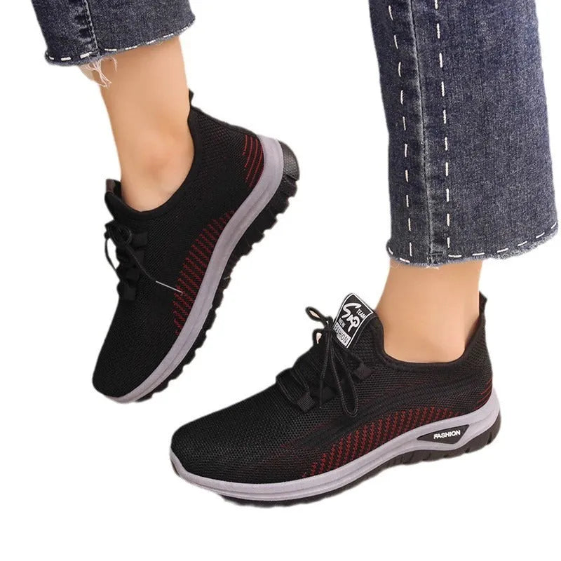 Women's black mesh sneakers with round toe, cross-strap details, and lace-up front on rubber sole