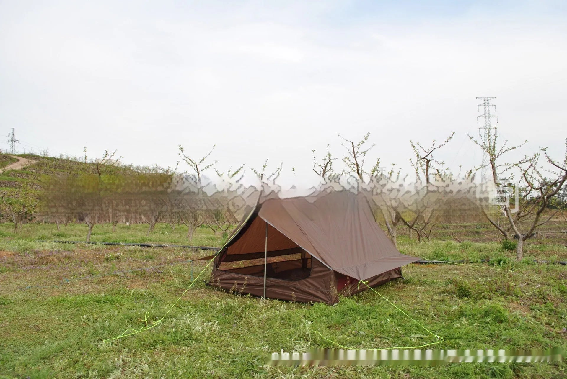 Brown A-line pole-free tent erected with hiking canes showing 2-3 person capacity and waterproof fabric construction