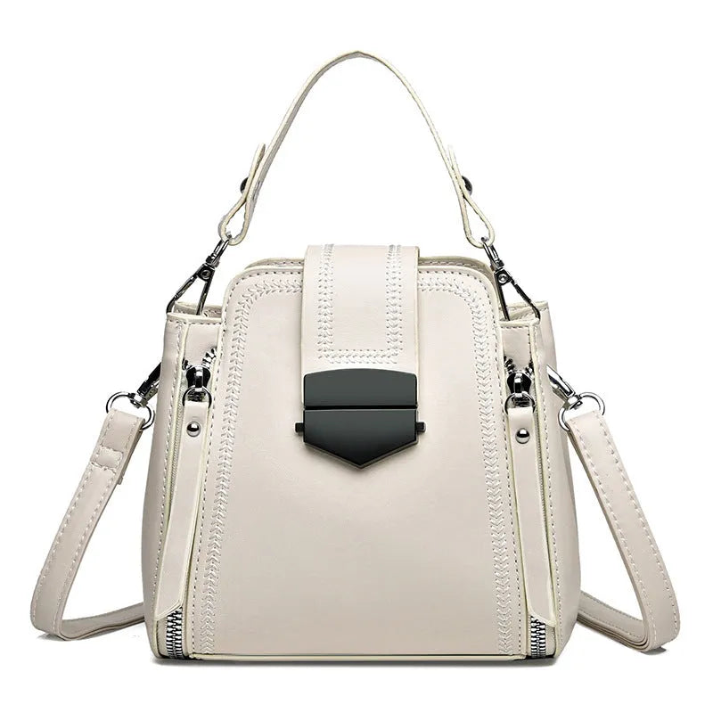 Soft textured PU leather ladies handbag in a square vertical shape with sewn thread detailing.