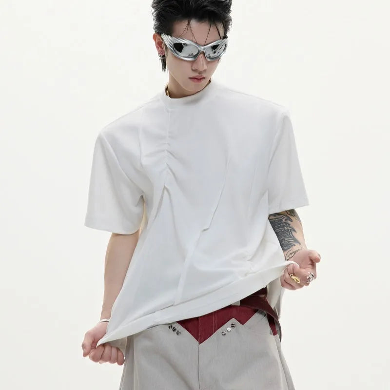 Man wearing a grey pleated cotton t-shirt with a round neck and loose fit.