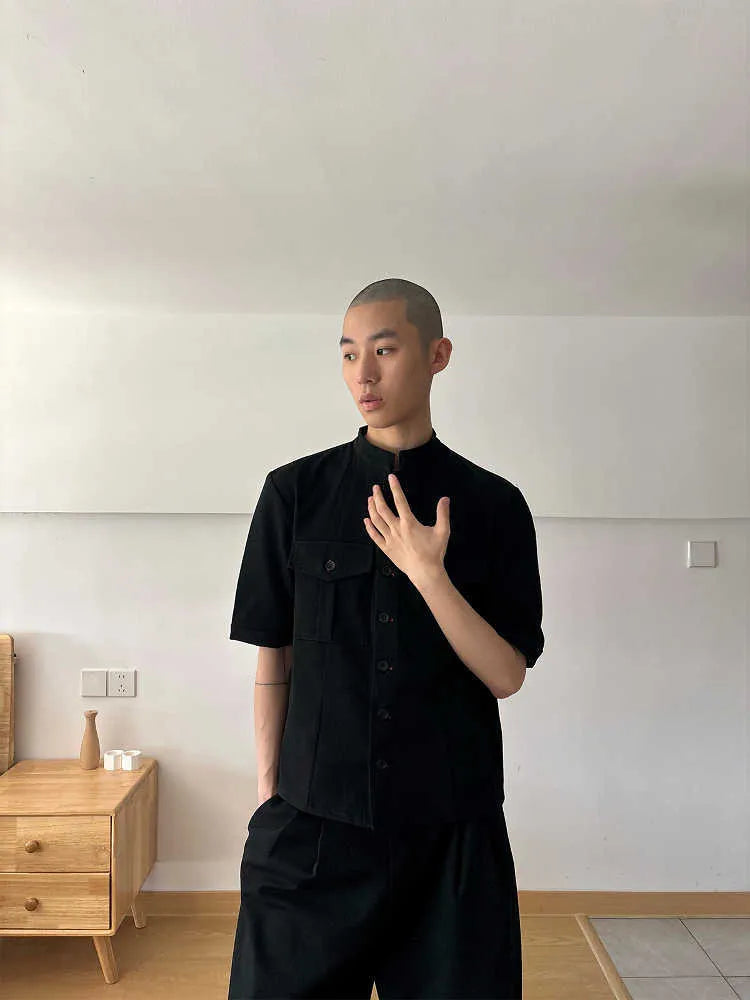 Handmade black half-sleeve shirt with a shirt collar and single-breasted front, shown in a loose fit.