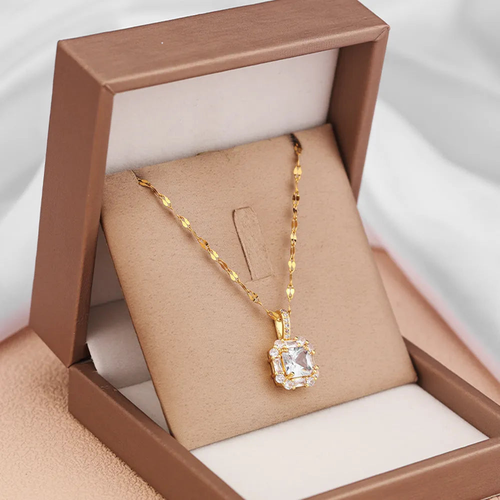 Gold-toned titanium steel necklace with geometric quadrilateral zircon pendant on a water wave chain.