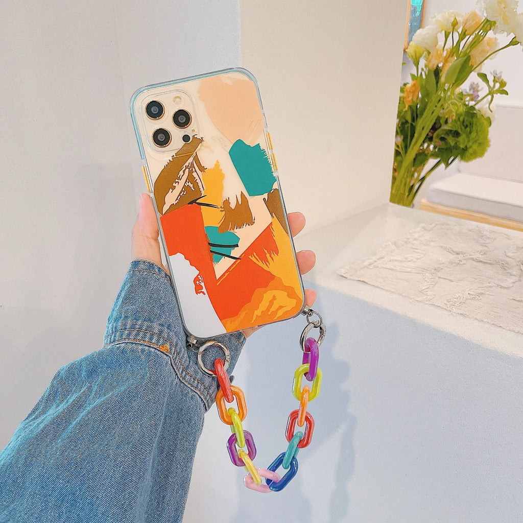 Pink iPhone case with a graffiti design and a white wrist strap attached.
