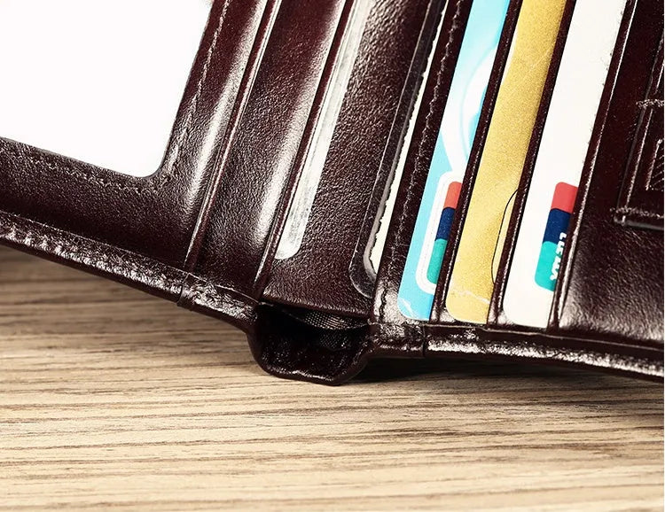 Men's brown leather bifold wallet open to show multiple card slots, a cash compartment, and a coin pocket.