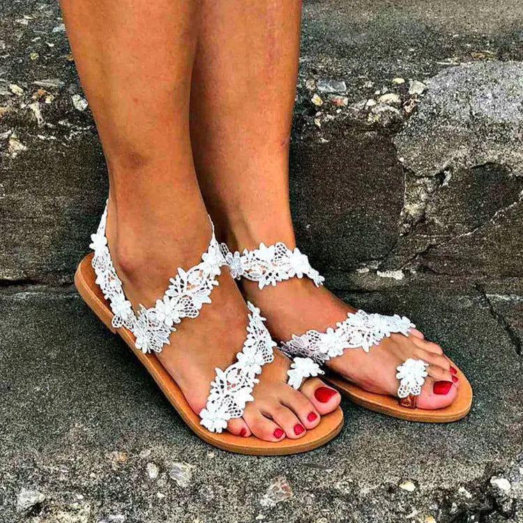 White women's flat sandals with floral patterns and rhinestones on a patent leather-look PU upper.
