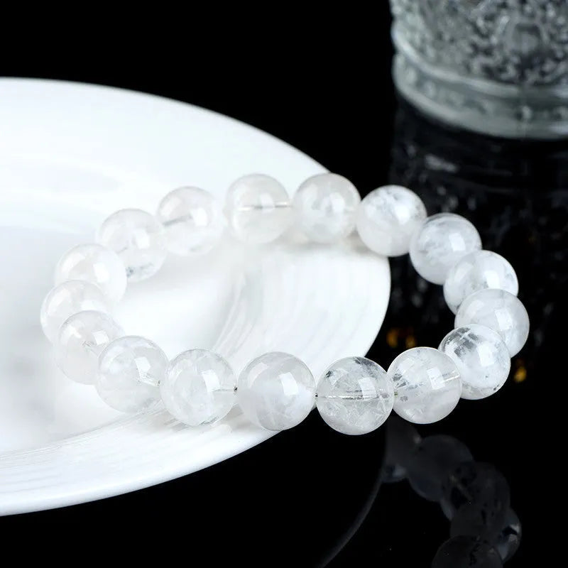 Geometric natural blizzard snowflake crystal women's bracelet with round beads on a white background.