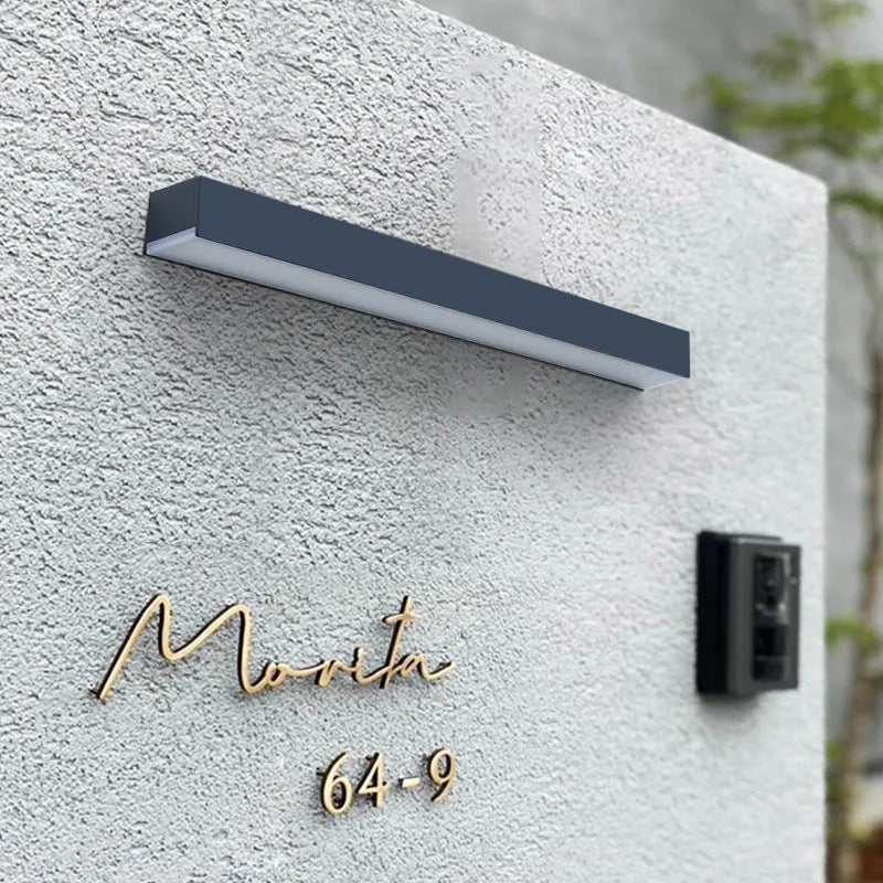 Black solar-powered outdoor wall lamp with solar strip, suitable for garden or yard.