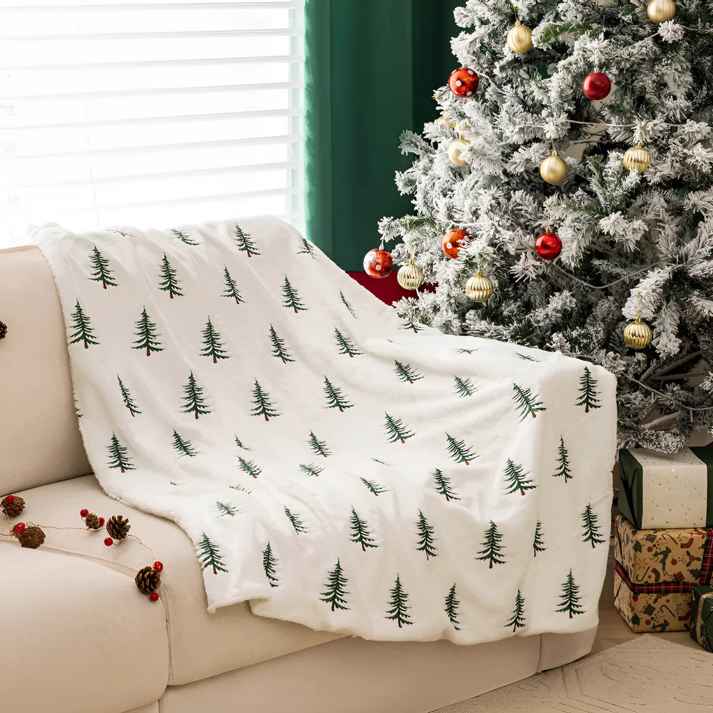 White Christmas plush sofa blanket with embroidered tree motif on a living room sofa