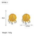 A pair of geometric gold metal earrings with round details on a white background.