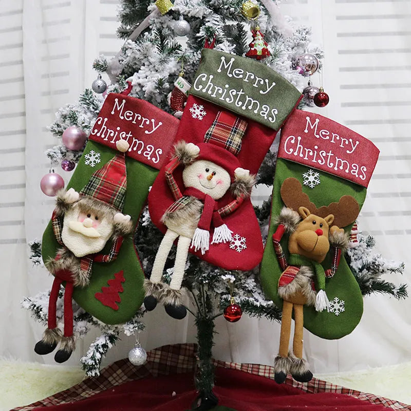 Three large Christmas stockings with Santa Snowman Reindeer 3D plush designs for holiday tree decoration